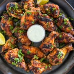 tandoori chicken wings on a serving plate with bleu cheese dip