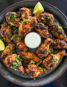 tandoori chicken wings on a serving plate with bleu cheese dip
